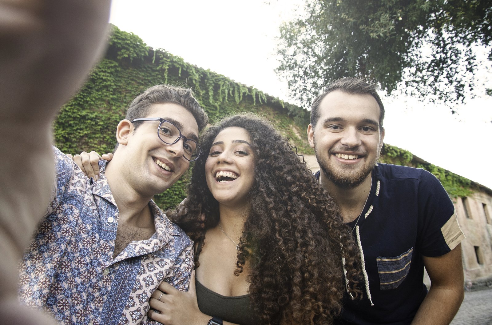 Three young people laughing together outdoors
